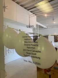 a group of white balloons hanging in a room